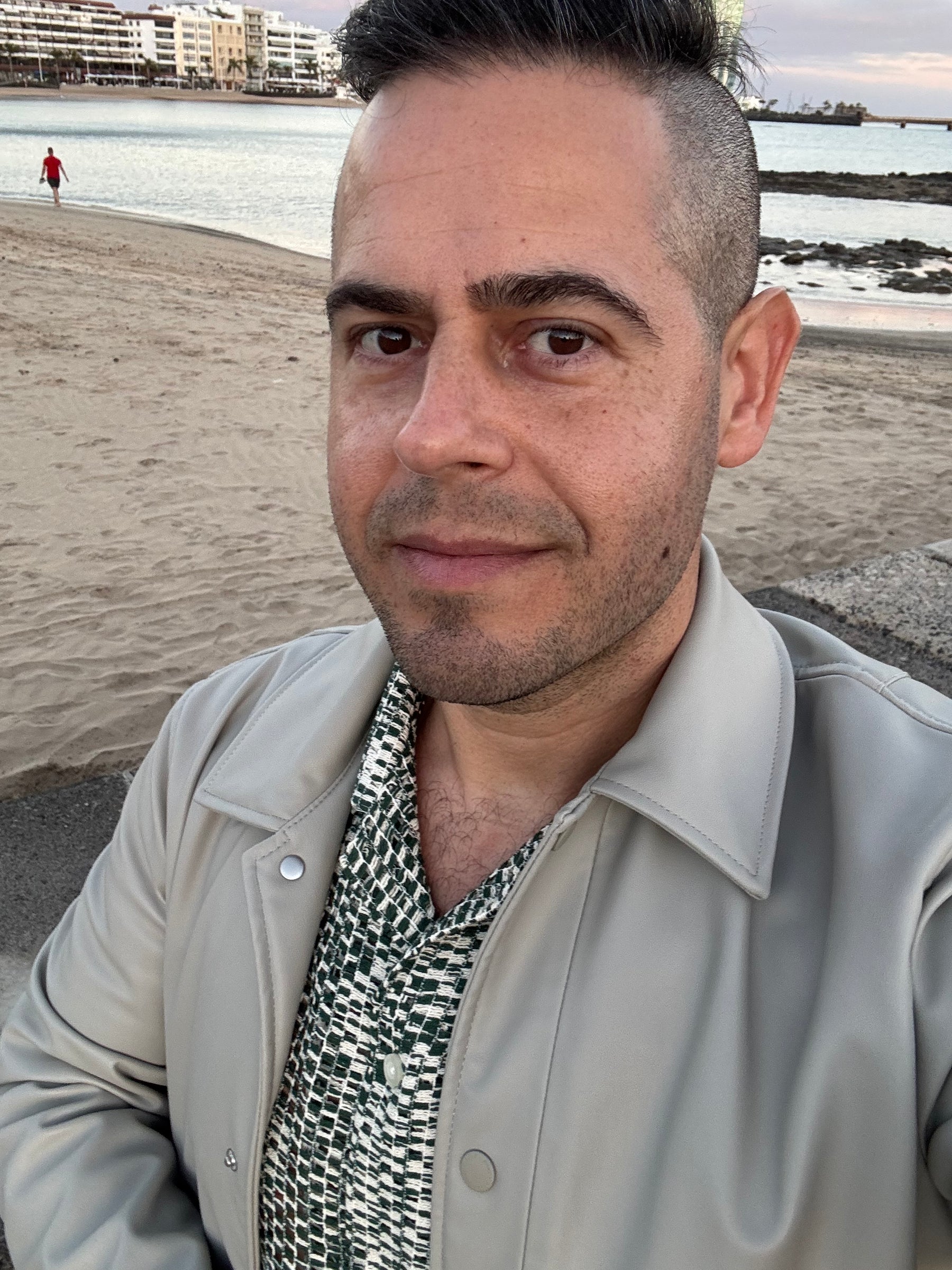 Jon Riesel in Arrecife wearing a light jacket by the waterfront