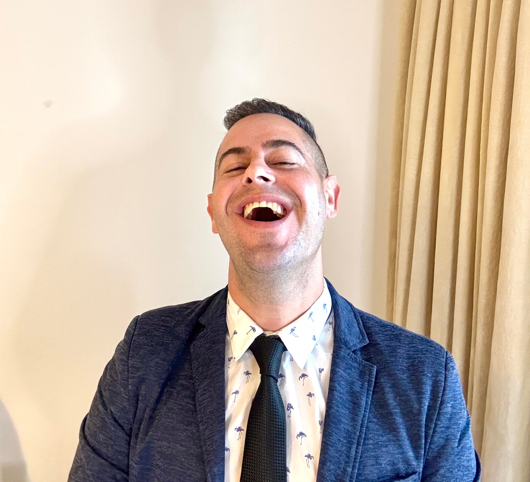 Jon Riesel laughing in a blue suit
